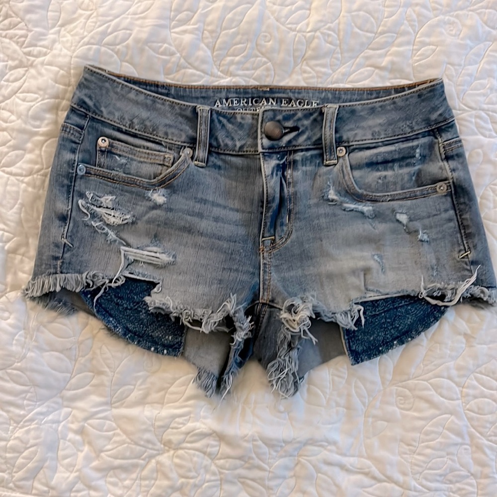 Distressed denim AE shorts. Knit pockets.